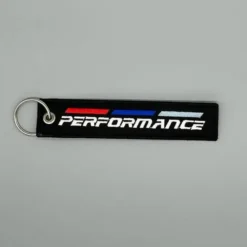BMW nyckelring i mjukt svart tyg med Performance-logotyp – stilren och bekväm design för BMW-entusiasten som vill ha sportig touch.