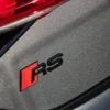 Stilrent Audi RS emblem i blanksvart – perfekt för bakluckan och en sportigare känsla.