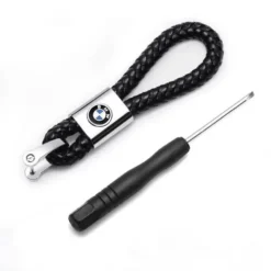 Elegant BMW nyckelring i flätad svart läder med metall och logotyp – en lyxig accessoar för alla BMW-ägare och bilentusiaster.