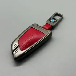 BMW nyckelfodral G-serie i röd design med matchande nyckelring – sportig elegans i metall och läder med perfekt passform.
