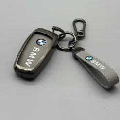 Exklusivt BMW nyckelskal i äkta läder med dekorativa vita sömmar och matchande metallnyckelring – en stilren och lyxig kombination.