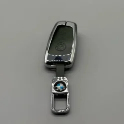 Lyxigt BMW nyckelskal i grön metallfinish med detaljer i läder och matchande nyckelring – en exklusiv accessoar för din bilnyckel.