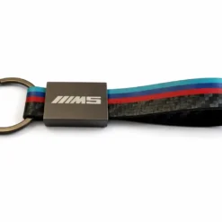BMW M5 nyckelring i kolfiber med metallfäste och M-ränder på vit bakgrund